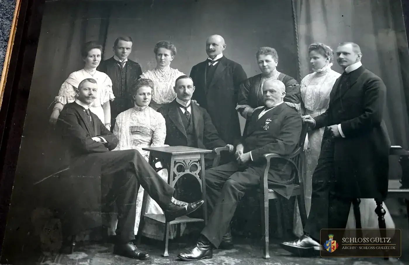 Atelier-Gruppenbild: elf Personen, in der Mitte vorn sitzend ein älterer Herr mit Ordensstern, um ihn Söhne, Töchter und Schwiegerkinder