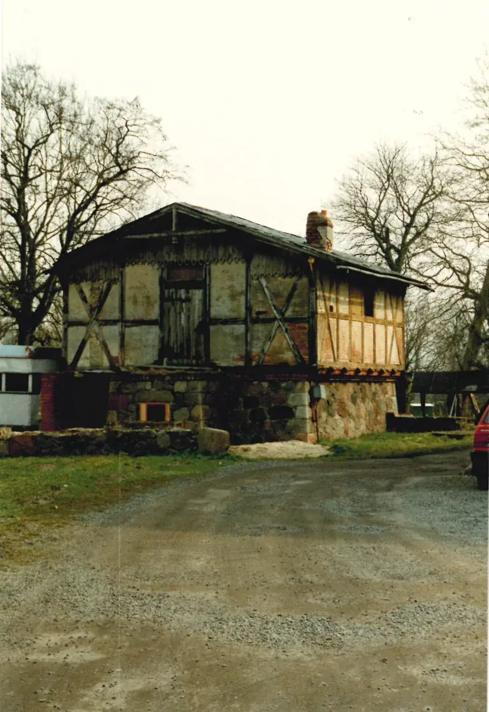 Geflügelstall der Gutsanlage Gültz im März 1995, Ansicht von der Zufahrt: Fachwerk auf Findlingssockel, Tor im Obergeschoss