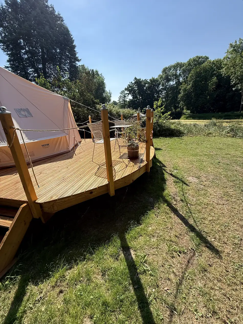 Deck and tent, with meadow and pond behind