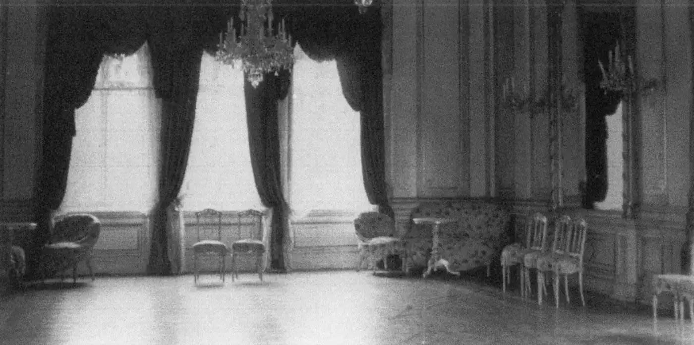 Der Gültzer Saal vor 1945: hohe Fenster mit schweren Vorhängen, Kronleuchter, zierliche Stühle und ein Sofa an den Wänden